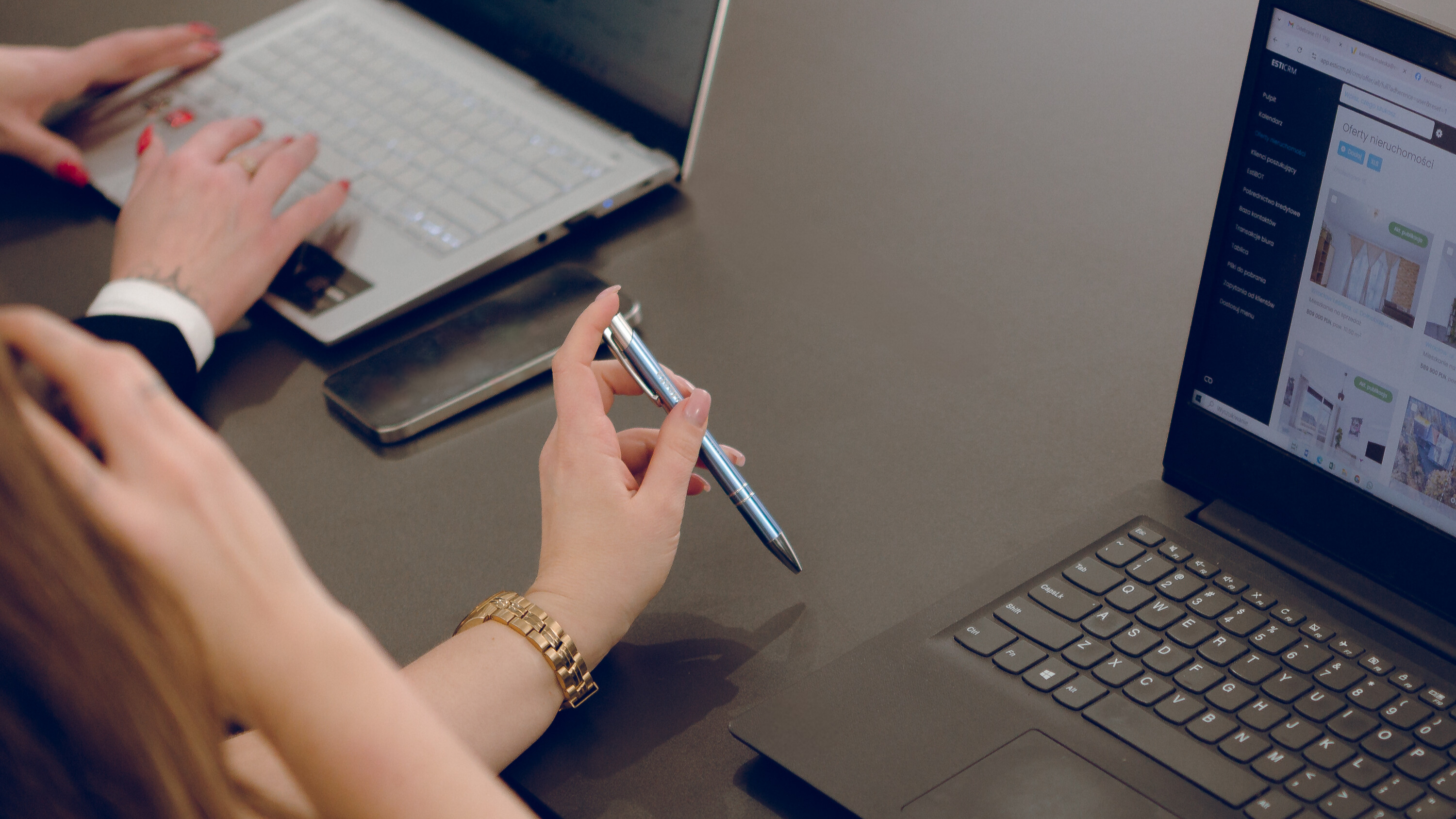 Współpracowniczki omawiają zawartość ekranu laptopa podczas pracy.